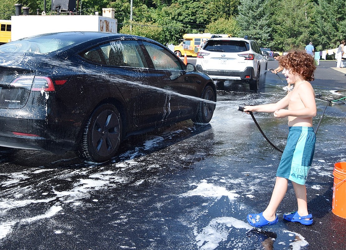 Ridge Street School third-grader Aiden Becher steps in to help out his older brother Noah’s teammates by taking a shift with the hose.