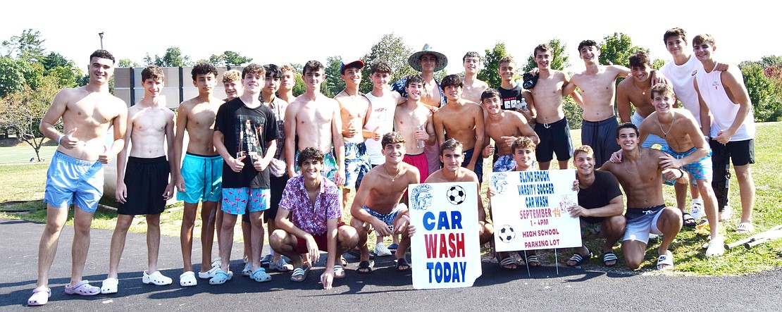 The Blind Brook boys’ varsity soccer team takes a break from washing cars to pose for a photo.