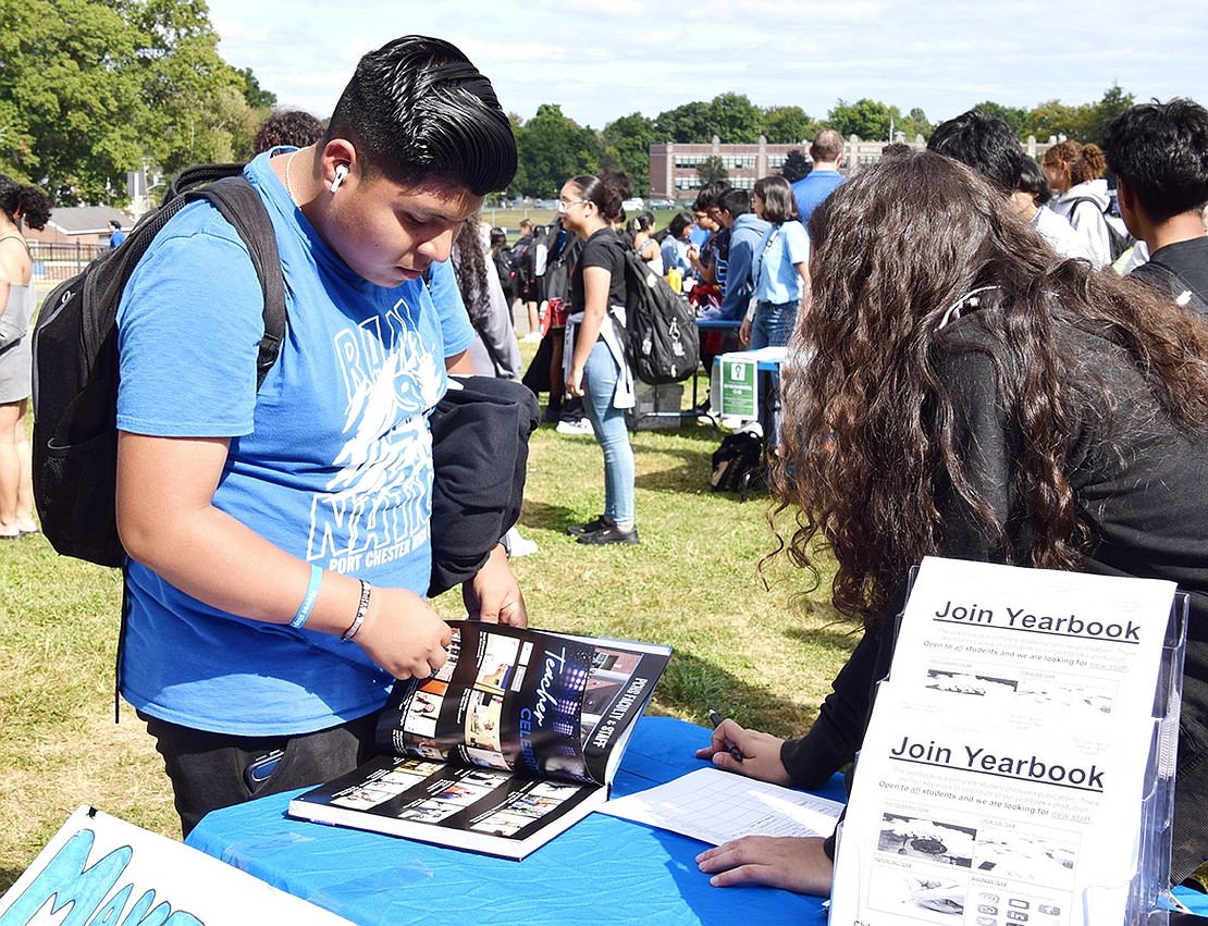 William Street resident Tony Nievescera (left), a senior, flips through the pages of last year’s yearbook as fellow senior Kristen Mejia talks him through what it was like making it.