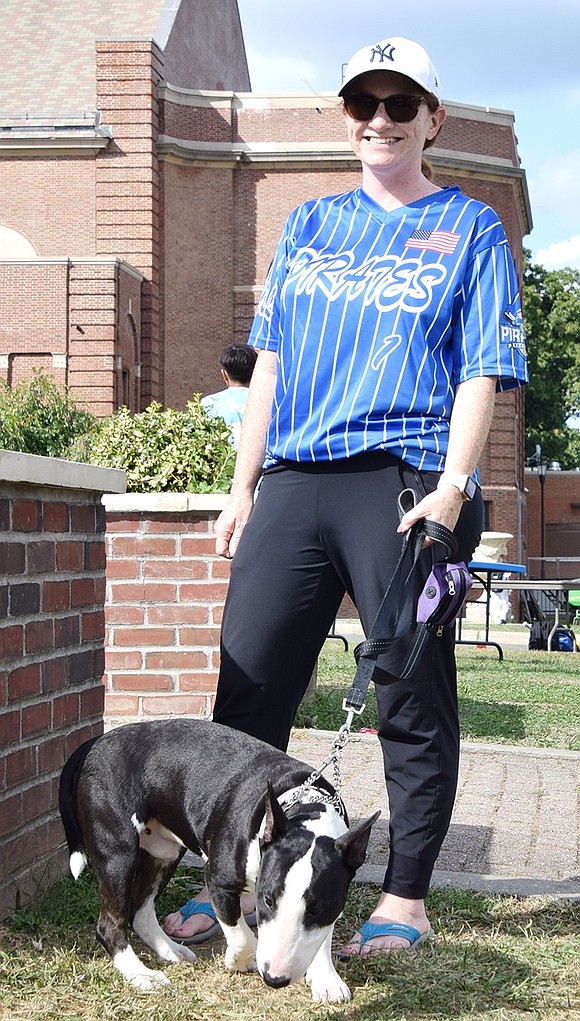 Joy Stroud, a Port Chester Youth Baseball League mom who lives nearby on Glen Avenue, and her 7-month-old mini-bull terrier Prince take a walk around the flagpole during the event.