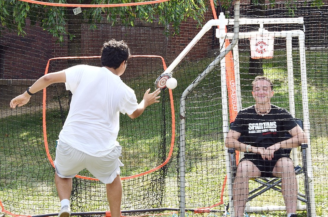 Freshman Oscar Morales of Breckenridge Avenue jokingly cheats by getting as close to the target as possible to knock a bucket of water onto his new band director, Isaac Schneider.