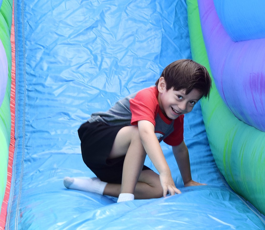 King Street Elementary School kindergartner Fernando Gomez laughs as he regains his balance after making his way down the inflatable slide during the annual Ramily Carnival at Port Chester High School on Friday, Sept. 20.