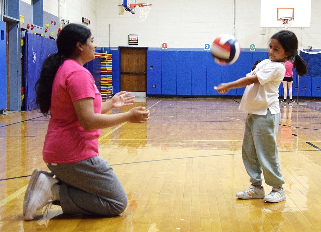 Blind Brook High School junior Tanisha Venkatapur gets low to show Ridge Street Elementary School third-grader Nysa Agrawal proper bumping form at a volleyball clinic held at the elementary school gym, an event that saw high school varsity players teaching younger Blind Brook students the finer skills of the sport on Tuesday, Sept. 24.