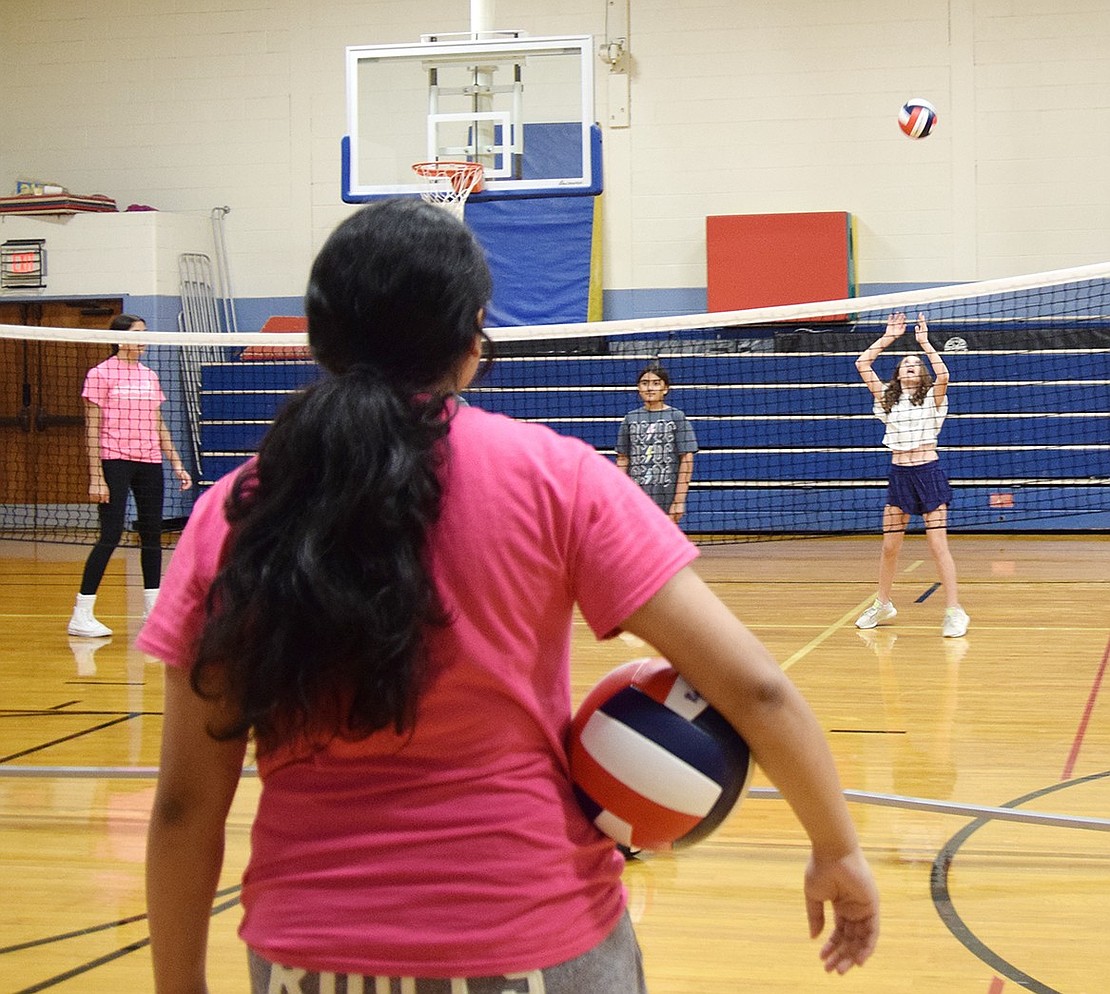 Heritage Court resident and varsity athlete Tanisha Venkatapur (left), a junior, observes as sixth-grader Victoria Bastone, a North Ridge Street resident, practices her sets.