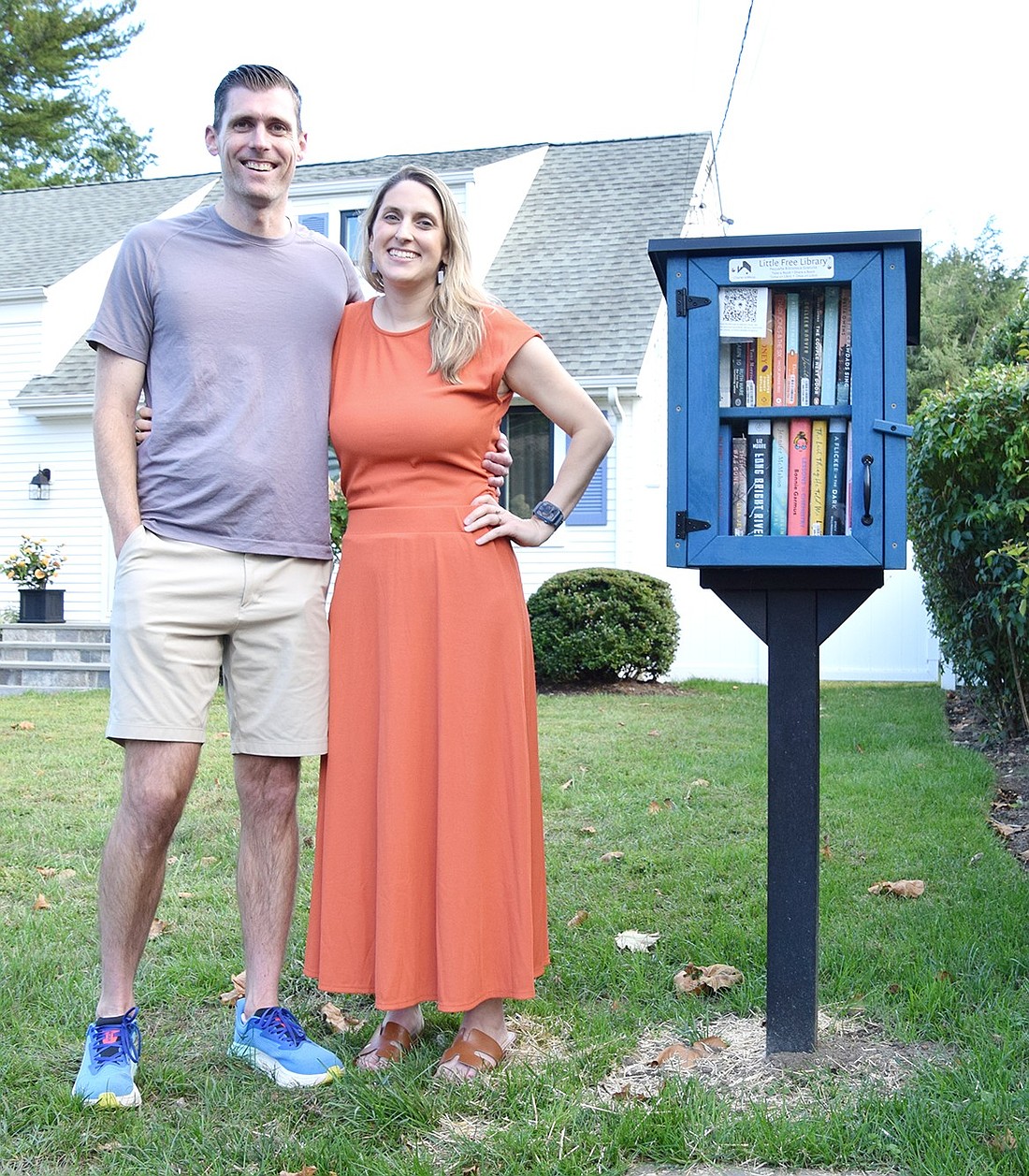 Calli Jones poses with her husband Tim by the Little Free Library they’ve built in front of their home at 24 Mitchell Pl. The exchange box is part of an international network created to encourage a love of literature.