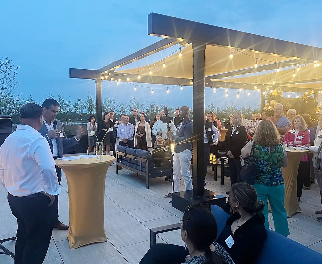 Ralph Rossi, CEO and founder of RMA Development, accompanied by his partner Andre Fernandes, speaks to the crowd gathered on The Magellan’s rooftop lounge for the grand opening celebration of the 108 S. Main St. building on Thursday, Sept. 26.