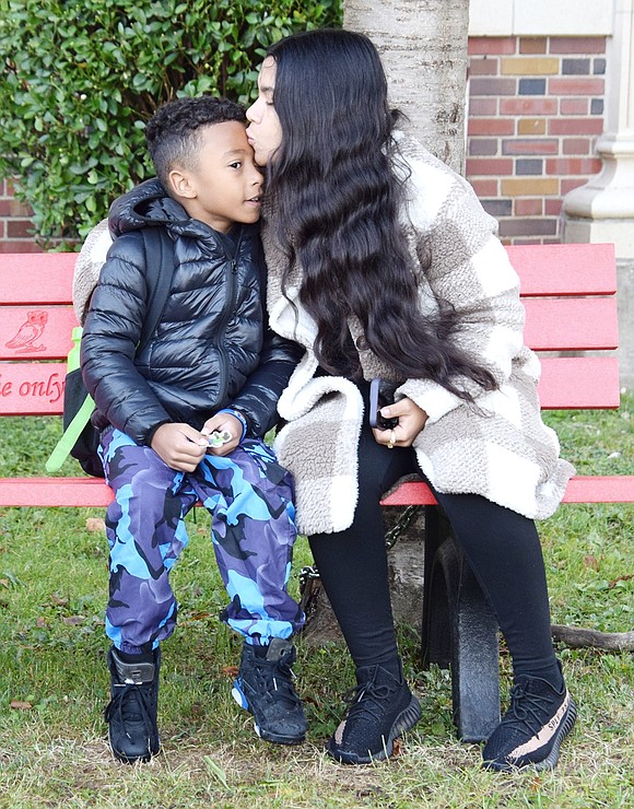 Kalexander Ceballos, 7, gets a farewell kiss from his mom Kia while sitting on a bench in front of Park Avenue Elementary School before he heads into his second-grade classroom.