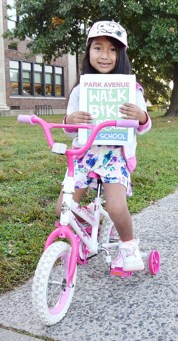 Park Avenue School first-grader Ana Pu Rucuch, a 5-year-old who lives on Westchester Avenue, poses for a photo after riding her bike to school with her dad.