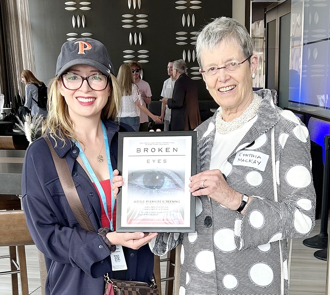 Dana Conroy (left) and Rye Brook resident Dr. Cynthia Mackay pose with a poster for “Broken Eyes,” an award-winning documentary they created to warn of the lesser-known consequences of the LASIK eye surgery, at the Minneapolis International Film Festival in April.