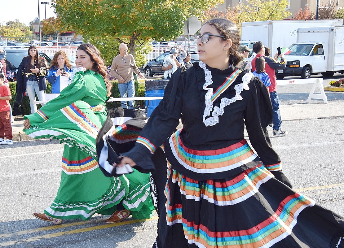 Dani Muratalla (in black), a 13-year-old eighth-grader at Port Chester Middle School, and Ely Valdovinos of King Street swing their folklórico dresses as they walk down Abendroth Avenue.