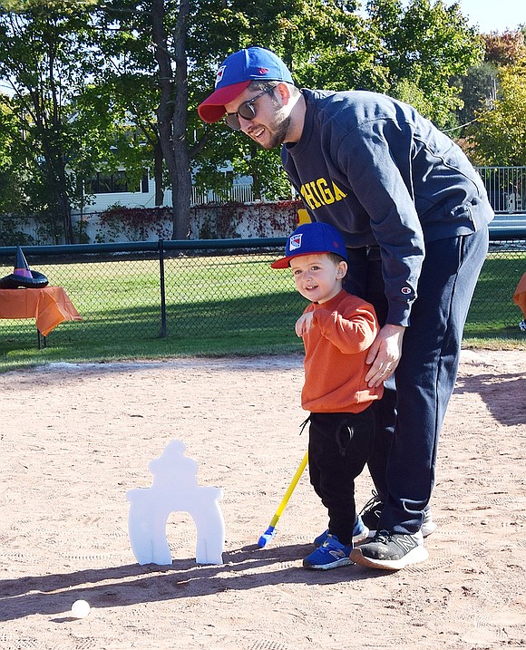 Country Ridge Drive resident Steven Zuckerman helps his 2-year-old son Jake play some mini-golf.