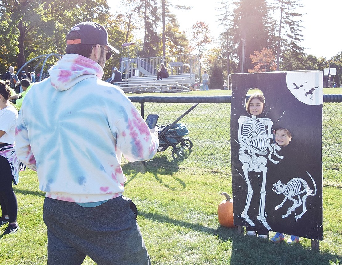 Like Halloween ghouls, a picture lasts forever. Windingwood Road resident Chris Georges snaps a commemorative photo of his children, Ridge Street School fourth-grader Edie and kindergartner Max, while they pose as skeletons in a cutout prop.