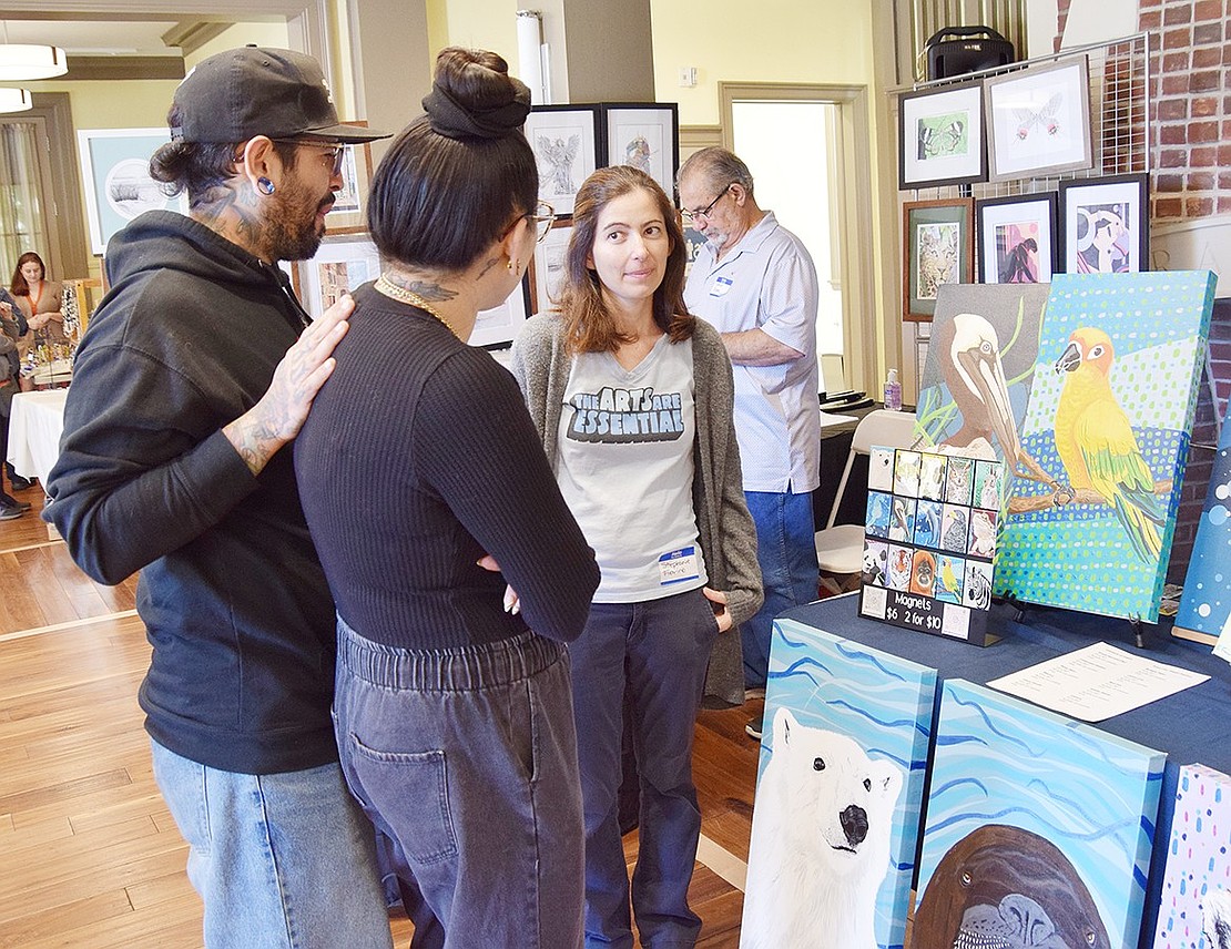 White Plains residents Michael Valentin and Keri D’Angelo speak with Stephanie Fiorino, a painter who lives on Valley Terrace, about her animal portraits.