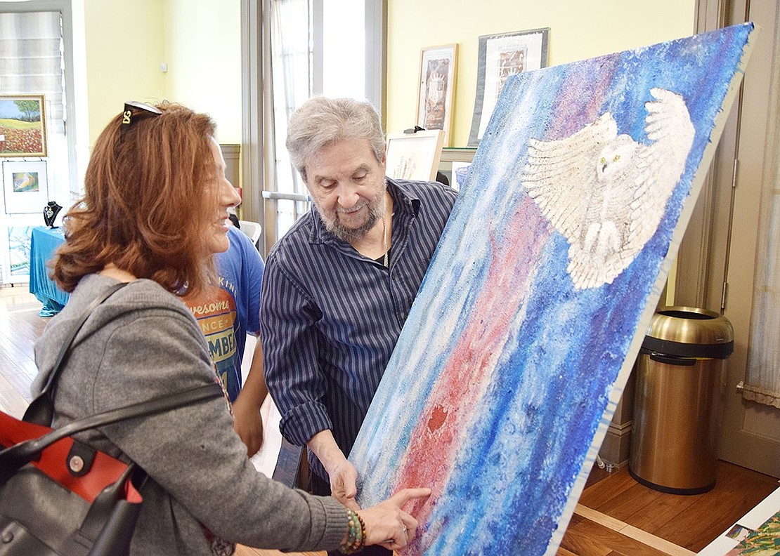 Betsy Brown Road, Port Chester, resident Kathy Casey gets a feel for the texture of one of Ossining-based artist Joseph de Matteo’s paintings.