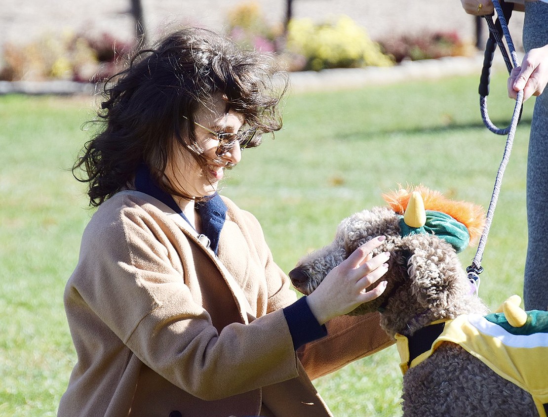 Visiting friends in her hometown, Alex Blaiotta, now a resident of New York City, helps adjust Olive the 3-year-old poodle’s Bowser costume before the contest begins.