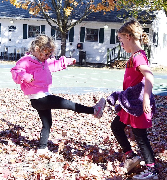 Ridge Street School kindergartners Lily Rabinowitz (left) and Emmanuelle Seidenfeld get into the fall spirit by playing in some leaves.