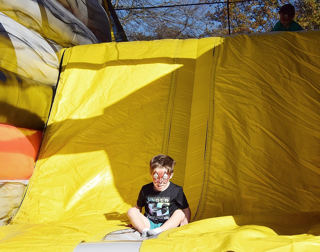 Seth Frenklakh, a 5-year-old Betsy Brown Road resident, sticks the landing as Spider-Man after taking a trip down one of the inflatable slides at Blind Brook Fall Fest on Saturday, Oct. 26. The annual PTA-sponsored event moved from Ridge Street School to the Mohawk Day Campgrounds in White Plains this year, inviting families to partake in carnival attractions.