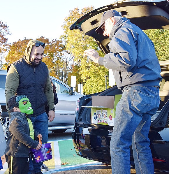 Washington Street resident Andrew Manousos (left) watches as his 3-year-old son Andrew Jr. spooks Rye Town Supervisor Gary Zuckerman with his Incredible Hulk costume.