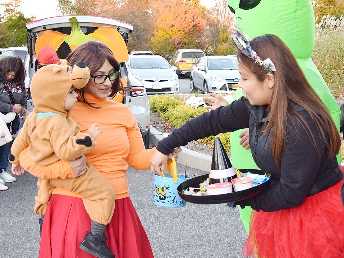 Hoping for a Scooby Snack, 19-month-old Aiden watches as his mom, Edely Valentine of Rye Brook, receives a treat from Deputy Rye Town Clerk Stephanie Maciel.