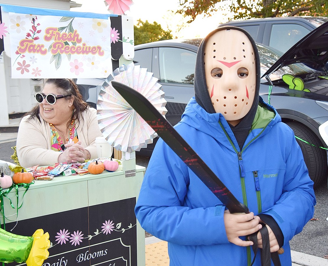 After picking up some candy from the newly appointed Rye Town Receiver of Taxes Carla Pugliese (left), Bronx resident Nicholas De La Rosa, 11, mimics Jason Vorhees and stares down the camera.