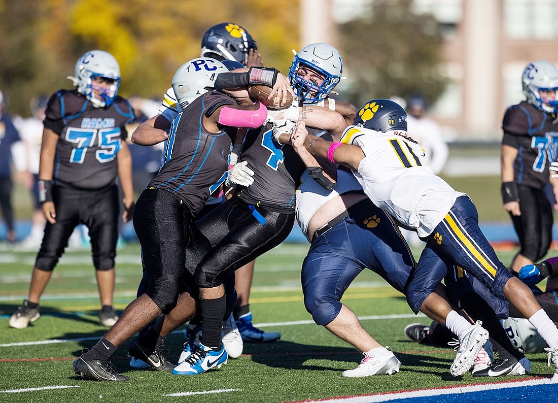 Rams senior fullback John Pauletti (#4) refuses to go down as evidenced by the way he keeps going with three Panas tacklers all over him. Pauletti scored the game-tying touchdown and the winning two-point conversion in Port Chester's 22-21 homecoming win with slightly more than three minutes left to play.