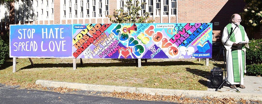 St. Paul’s Lutheran Church Pastor Jim O’Hanlon speaks during the unveiling of the “Love” mural on Oct. 6. The traveling artwork was created for the 2023 Pride Festival at Rye Town Park and was displayed at various parks before moving to its new home at 761 King St.