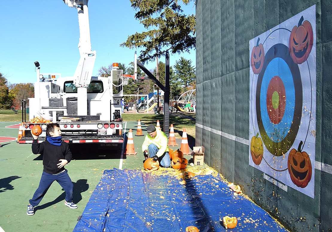 John Luigi Castellano, a 7-year-old first-grader at Ridge Street Elementary School, winds up to hurl his small gourd at the target set up for residents to aim at.