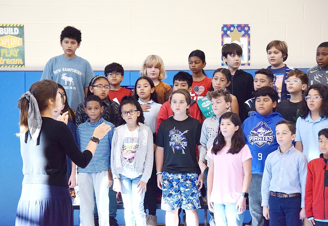 Victoria Crecco, a King Street School vocal music teacher, directs members of the fifth-grade Glee Club through a rendition of “God Bless America.”