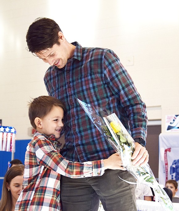 Washington Street resident, West Point graduate and U.S. Army veteran Chris Blair hugs his son Bobby, a first-grader at King Street School.