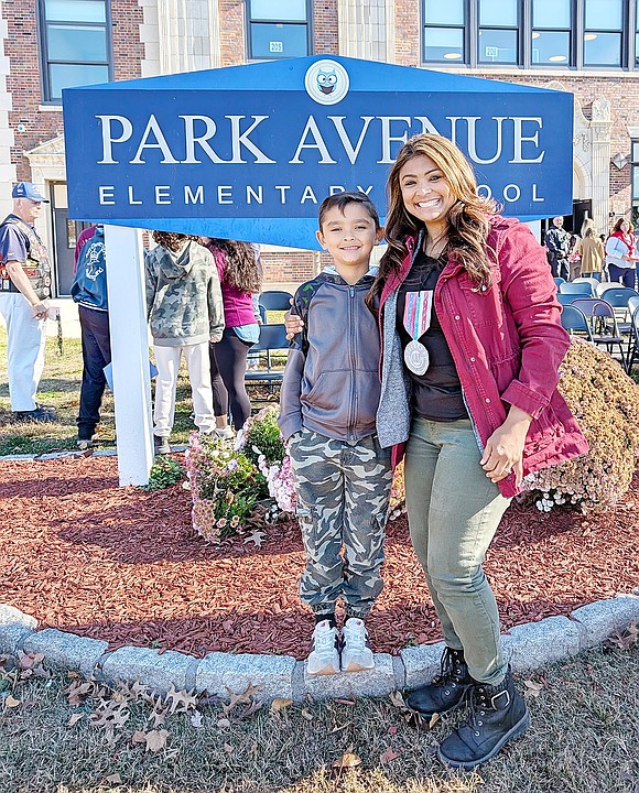 U.S. Army Specialist Desiree Morris and her son Sean, a Park Avenue Elementary School second-grader, pose in front of his school.