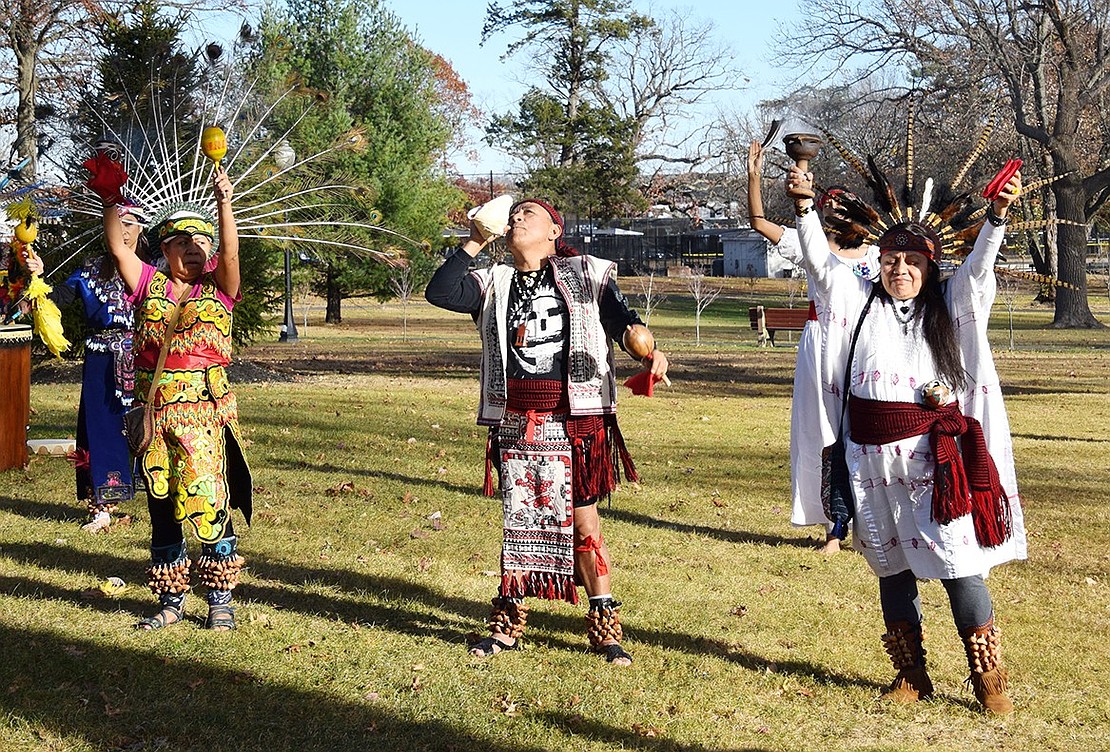 Sosimo Nolasco (center) blows into a conch shell as Maria Pacheco (left) and Lily Rojas pay their respect to the four elements and deities associated with the cardinal directions ahead of their performance.