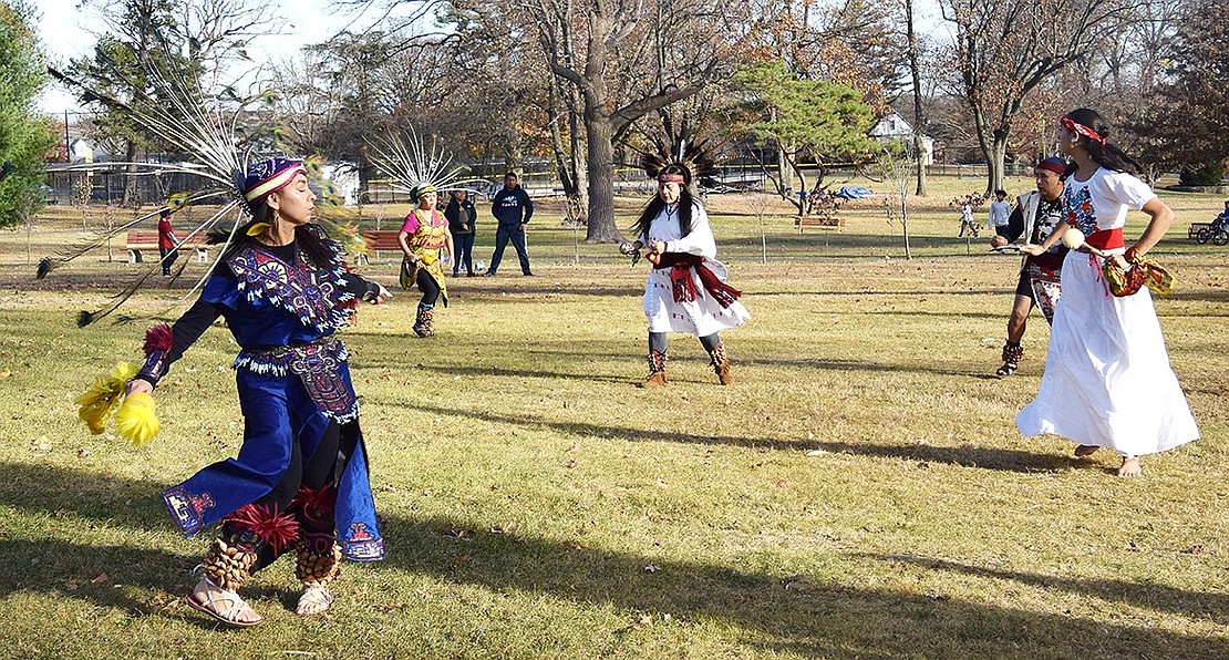 Port Chester resident Claudia Mora (left) performs a traditional Aztec dance with the rest of the troupe on the grass of Lyon Park.