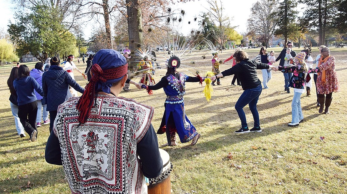 Sosimo Nolasco, a traditional Aztec dancer from Queens, plays the drum as event attendees join hands and dance together.