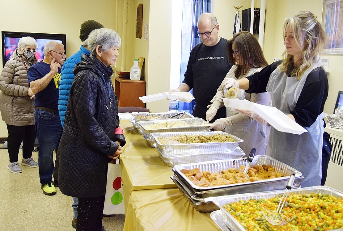 Longtime volunteers Joseph Tallone of Yonkers, Lisa Fiorino of Mamaroneck and Nicole Conlisk of New Rochelle dish out a perfect Thanksgiving dinner—turkey and all the sides—to residents of the Terrace Avenue senior housing complex in Port Chester lined up in their community room on Saturday, Nov. 23. It was Corporate Outreach’s 38th annual Thanksgiving dinner for the less fortunate. A similar scene played out at the Drew Street senior housing complex the same day.