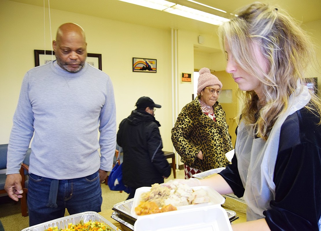 Fifteen-year volunteer Nicole Conlisk of New Rochelle puts the finishing touches on Terrace Avenue resident David Williams’ delicious-looking Thanksgiving dinner.