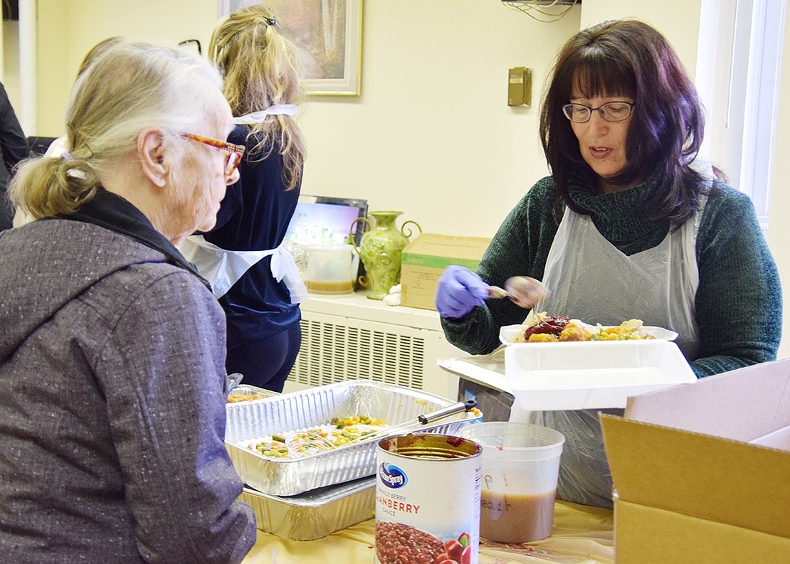 Twenty-year volunteer Christine Keller of Pelham tops off 101-year-old Terrace Avenue resident Helen Marynowski’s plate with cranberry sauce.