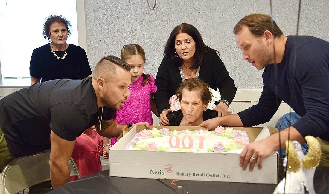 After a room of over 100 guests sing “Happy Birthday,” family members help Bea Conetta blow out candles on her cake celebrating her turning 100 years old on Sunday, Nov. 24. Behind her is her daughter Geraldine Colucci and great-granddaughter Grace Catino. To the left is her grandson Rick Franchella, and Adam Franchella is on the right.