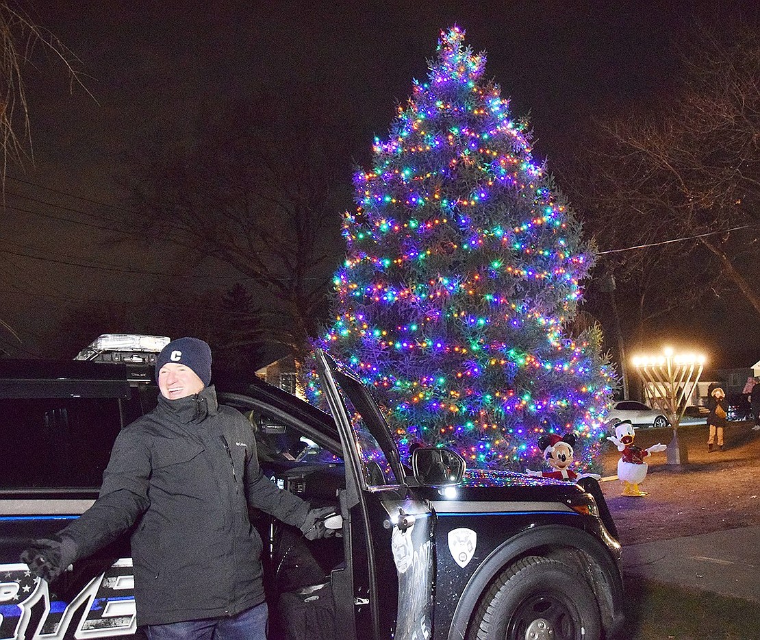 Rye Brook Mayor Jason Klein has a laugh after using the intercom of a police cruiser to count down the ceremonial lighting of the Christmas tree and menorah.