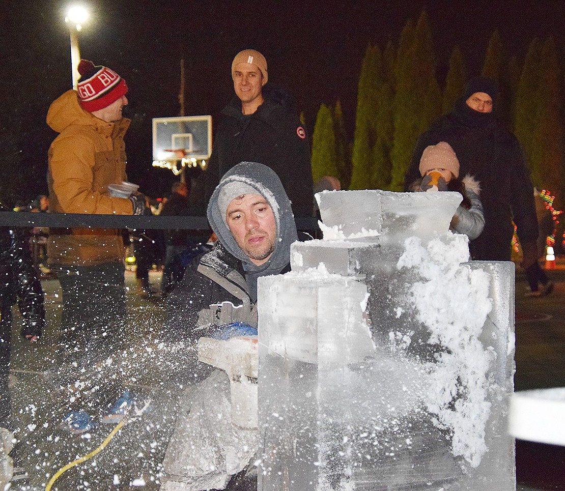 Ice Memories master ice carver Rich Daly draws a crowd as he starts cutting a block into the shape of Frosty the Snowman.