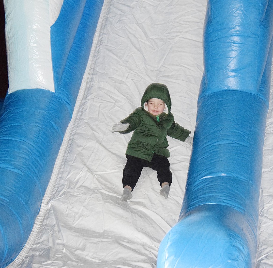 Rye Brook resident Leo Chandiramani, 3, speeds down an inflatable slide set up outside the Crawford Mansion Community Center.