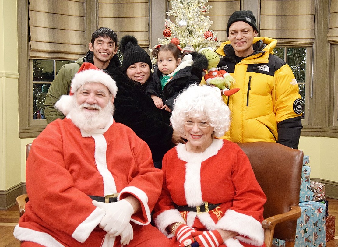 Mamaroneck residents Ariel Cruz (left), Kayla Cruz, 2-year-old Joyce Cornejo and Juan Cornejo pose with Santa and Mrs. Claus, who usually masquerade as Charlie Sacco and Rye Town Clerk Hope Vespia.