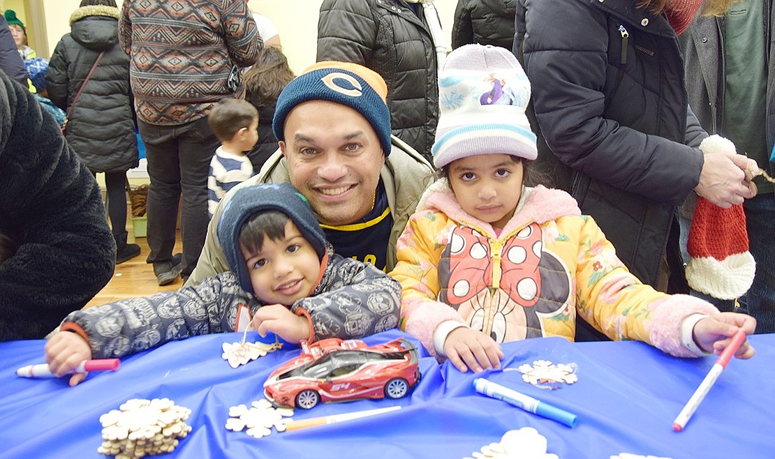 George Chacko, a Berkley Drive resident, poses for a photo with his 2-year-old son Micah and 4-year-old daughter Jordyn in an activity room set up in the Crawford Mansion Community Center at the Town of Rye’s annual Holiday Lights celebration on Saturday, Dec. 7. The event drew hundreds looking to get into the holiday spirit.