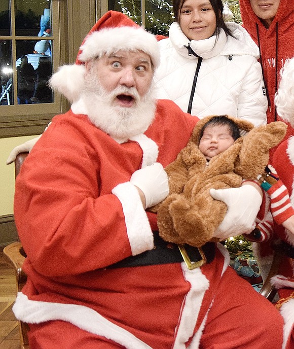 Santa Claus channels his inner Charlie Sacco, who he also goes by while taking a break from the holidays, as he poses with 1-month-old Ian Fuentes of North Regent Street at the Town of Rye’s Holiday Lights celebration at Crawford Park on Saturday, Dec. 7.