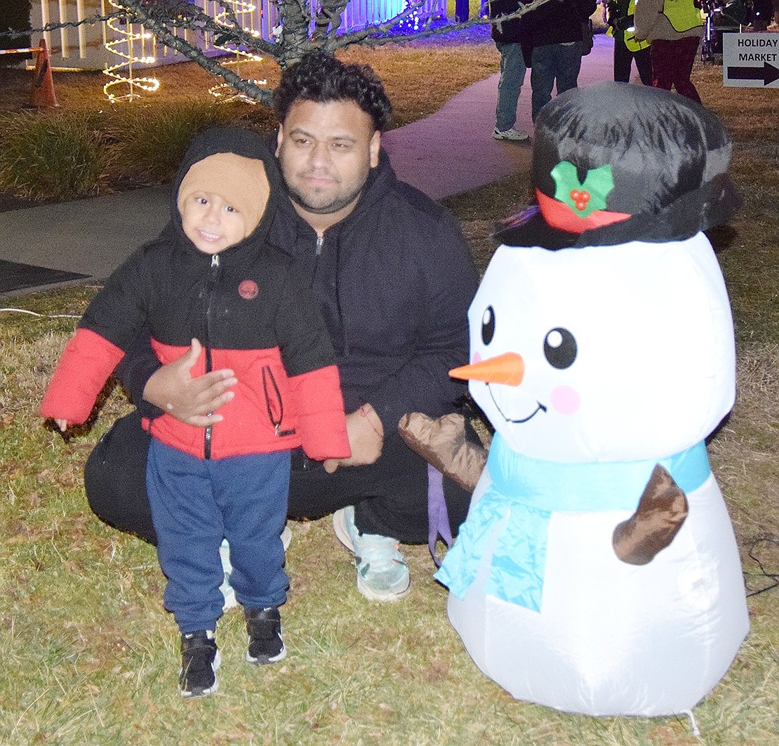 Excited to meet Frosty the Snowman, Orchard Street resident Leo Santillan, 3, poses alongside his dad Jesus for a photo.