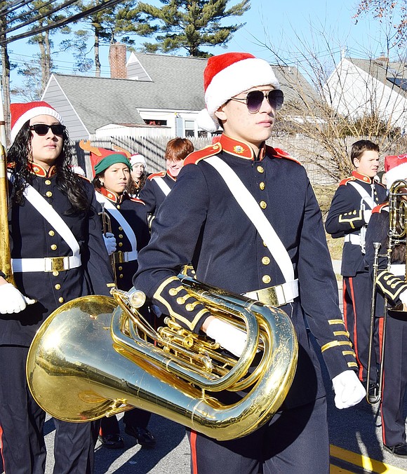 Senior tuba section leader Gabriel Franco carries his instrument on the partly sunny day.