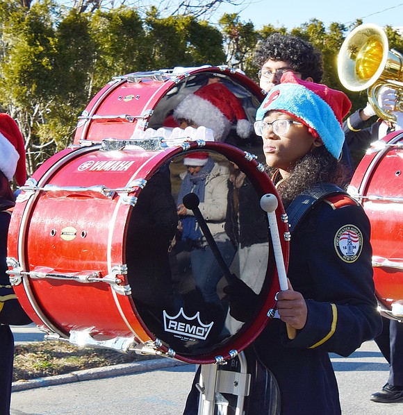 Port Chester High School sophomore Faith Adamson stands out with a Spider-Man themed Christmas hat while marching with her bass drum.