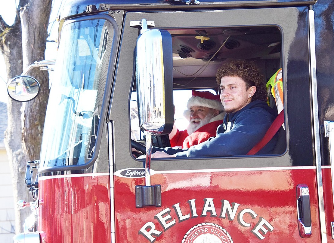 Port Chester firefighter Joshua Negron drives Santa Claus (also known as Charlie Sacco) down King Street toward Lyon Park during the parade.