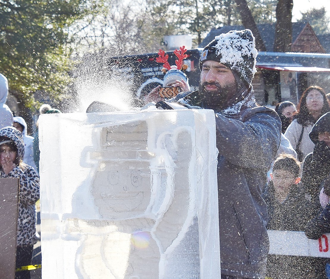 James Neary, an ice sculptor with the Long Island-based Ice Memories, works on carving a snowman.