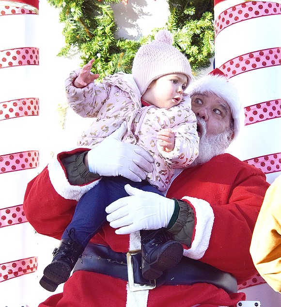 “We’ve got a wrestler,” Santa Claus, otherwise known as Charlie Sacco, cries as 1-year-old Port Chester resident Cora Biederbeck attempts to jump out of his arms at the annual Christmas Parade and Santa in the Park event at Lyon Park on Saturday, Dec. 14.