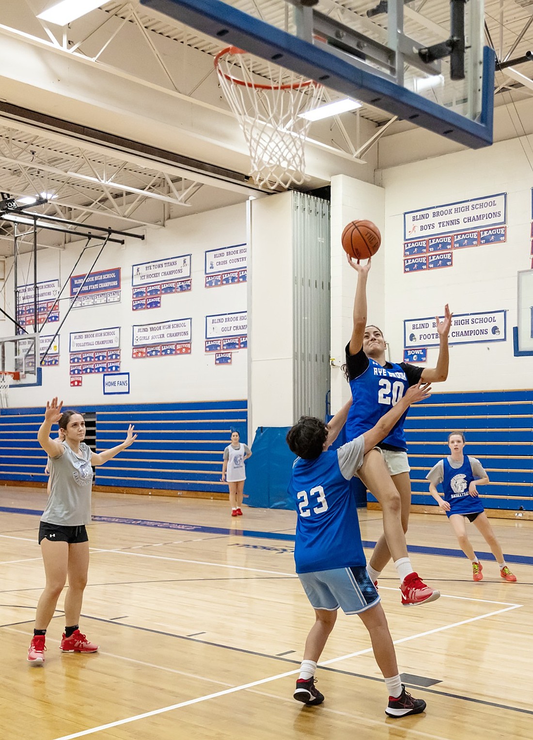 Junior Ella Rosenfeld attempts to shoot a layup while being guarded by team manager Natalie Genovese during basketball practice in the Blind Brook High School gym on Monday, Dec. 16.